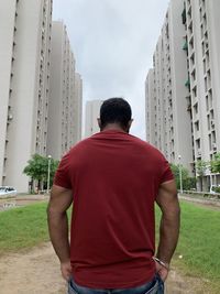 Rear view of man standing by buildings in city