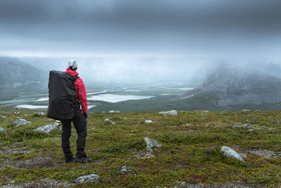 Man standing on mountain against sky