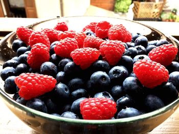 Raspberries and blueberries in bowl on table