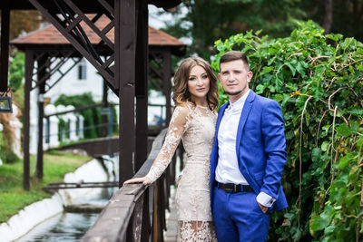 Portrait of couple standing against plants