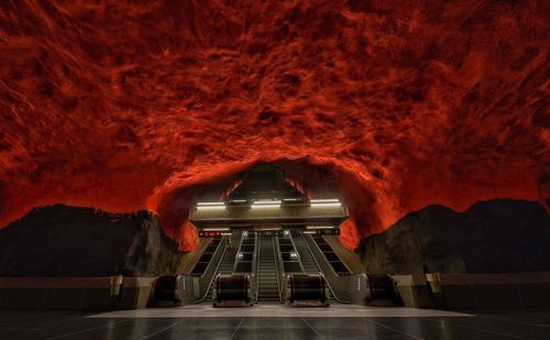 View of illuminated escalator with orange ceiling at night