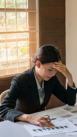 Businesswoman doing paperwork on desk at office