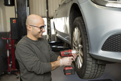 Happy car mechanic working in garage