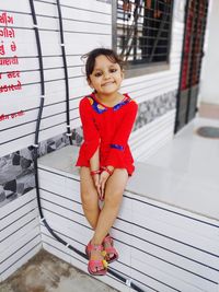 Portrait of smiling girl sitting outdoors