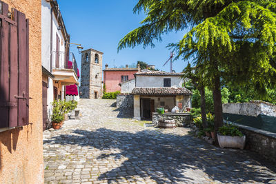 Footpath amidst buildings against sky