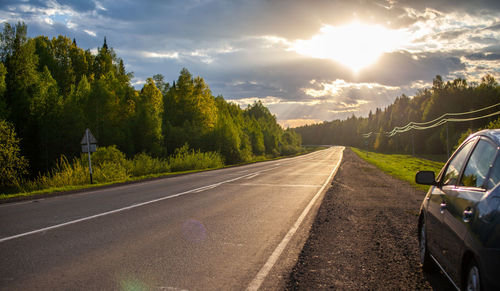 Road amidst trees against sky