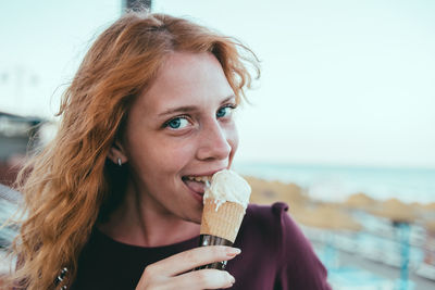 Close-up portrait of young woman eating ice cream