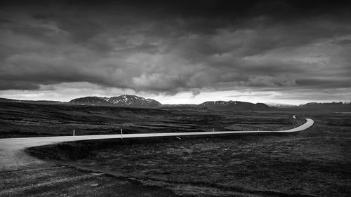 Scenic view of mountain road against cloudy sky