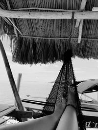 Low section of woman relaxing on hammock at swimming pool