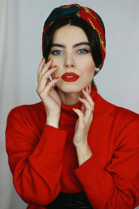 Portrait of young woman against white background red lipstick