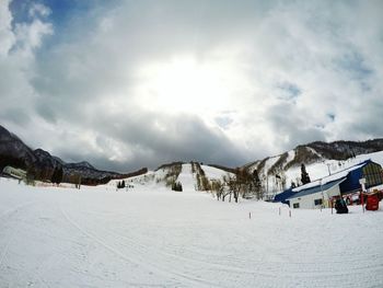 Scenic view of snowcapped mountain against cloudy sky