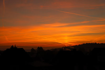 Scenic view of silhouette trees against orange sky