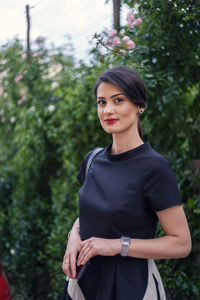 Portrait of woman standing against plants