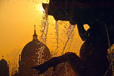 Water falling from fountain at sunset