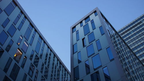 Low angle view of office building against clear blue sky