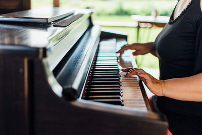 Midsection of woman playing piano