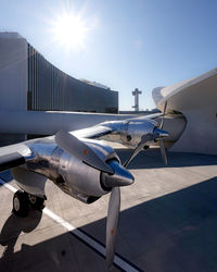 High angle view of airplane wing and propeller engines next to terminal and control tower