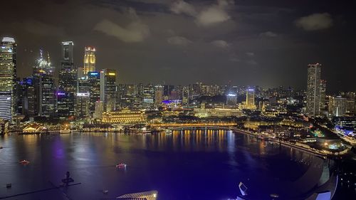 Illuminated buildings in city against sky at night