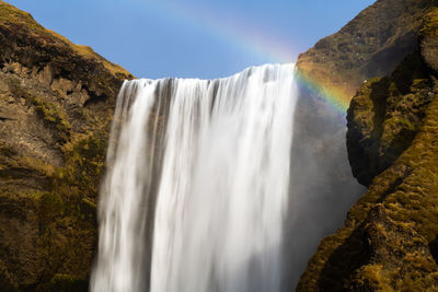 Scenic skogafoss waterfall with rainbow on a calm bright day in iceland