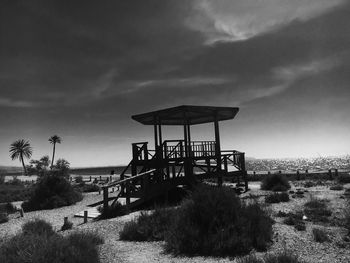 Lifeguard hut on field against sky