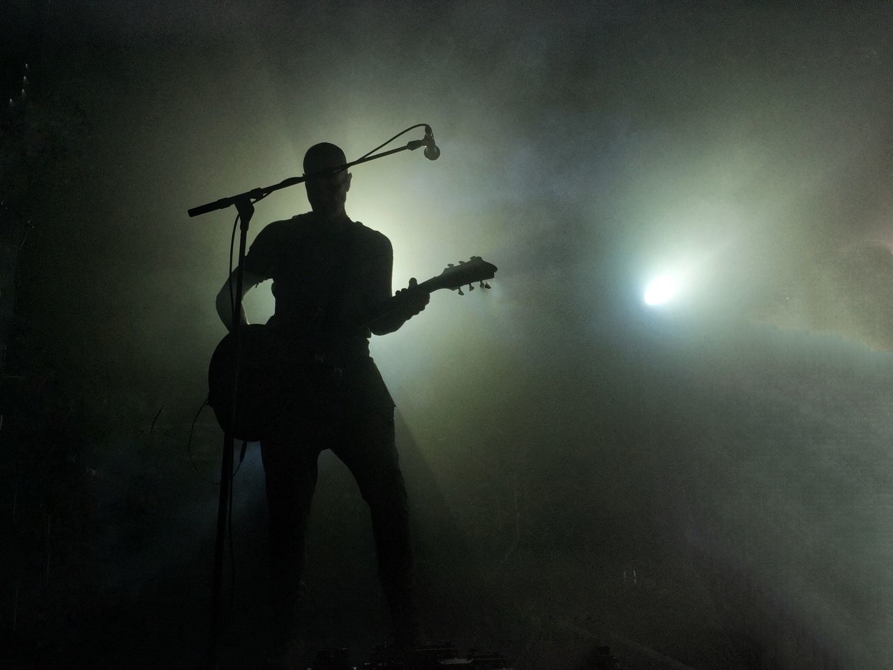 musical instrument, music, guitar, arts culture and entertainment, performance, musician, string instrument, artist, guitarist, playing, silhouette, stage - performance space, stage, musical equipment, nightlife, illuminated, night, standing, holding, lighting equipment, skill, light, plucking an instrument, rock music, entertainment occupation, concert, electric guitar