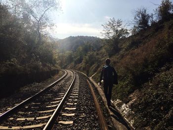 Friends standing by railroad track amidst hills