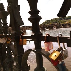 Close-up of padlocks on railing against bridge