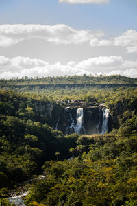 Scenic view of waterfall against sky