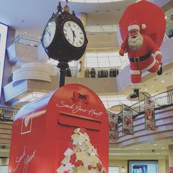 Low angle view of clock hanging against building