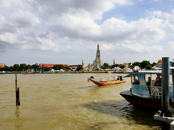 Boats in canal against buildings in city