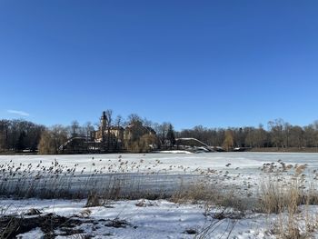 Snow covered field against clear sky