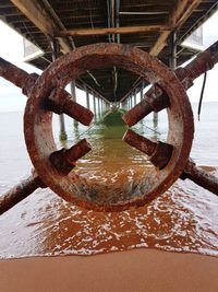 Close-up of rusty chain on sea shore