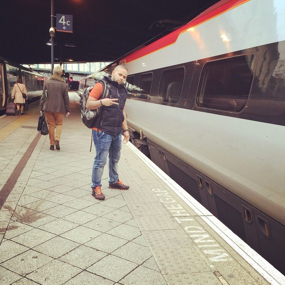 full length, lifestyles, transportation, casual clothing, men, leisure activity, railroad track, walking, built structure, night, city life, architecture, person, rear view, building exterior, mode of transport, railroad station platform, standing