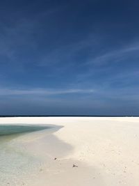 Scenic view of beach against blue sky