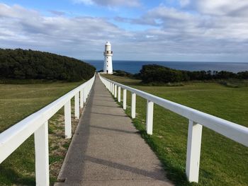 Lighthouse by sea against sky