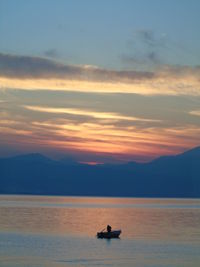 Silhouette boat sailing on sea against sky during sunset