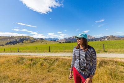 Woman standing on field against sky