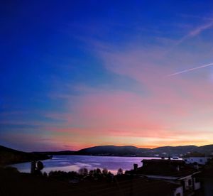 Scenic view of vapor trails in sky at sunset