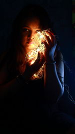 Portrait of woman holding burning candle