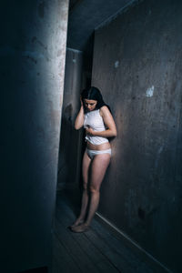 Full length of woman standing against wall