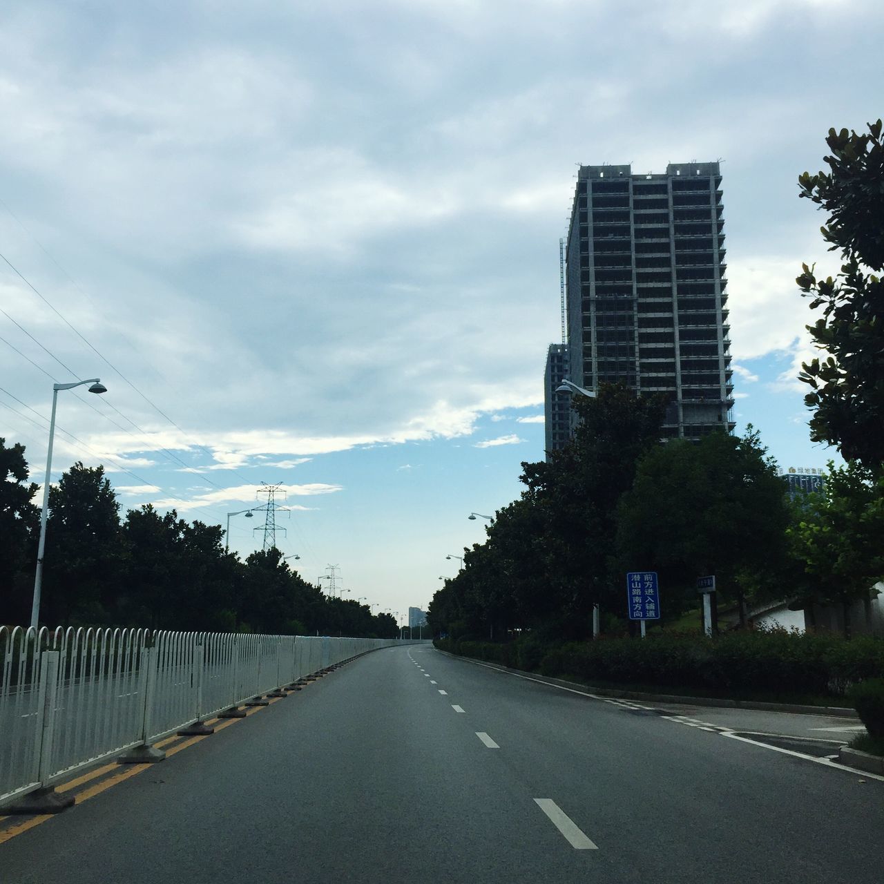 the way forward, diminishing perspective, road, sky, architecture, vanishing point, built structure, road marking, empty road, cloud - sky, tree, empty, long, cloudy, city, cloud, outdoors, no people, day, tall - high, overcast, nature