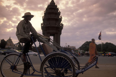 People on bicycle against sky during sunset