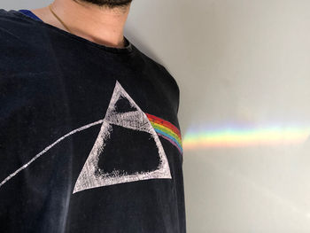 Midsection of man standing against rainbow in wall
