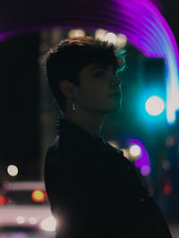 Portrait of young man looking away at night