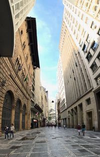 People walking on street amidst buildings in city