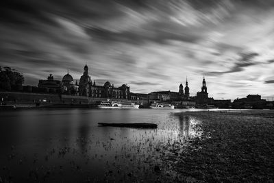 River in city against cloudy sky