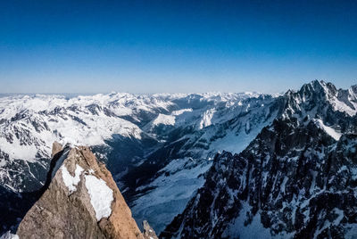 Scenic view of snowcapped mountains against clear blue sky