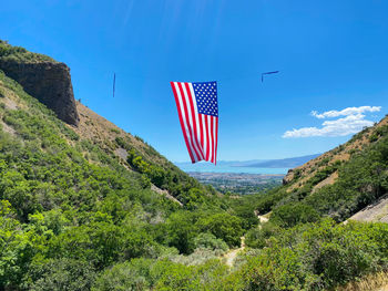 Scenic view of flag on mountain against blue sky