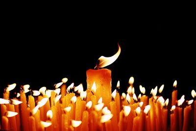 Close-up of lit candles against black background