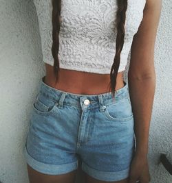 Midsection of woman standing against wall